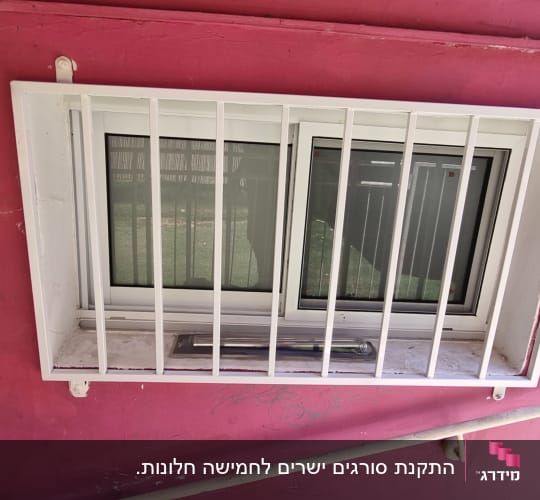 סורגים ישרים ממתכת בצבע לבן המותקנים על גבי חלון